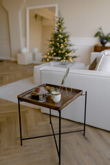 Gold chain on a wooden stand Accessories for a woman on a stylish table in the living room Mirror mug and candle for a cozy and festive atmosphere in the house