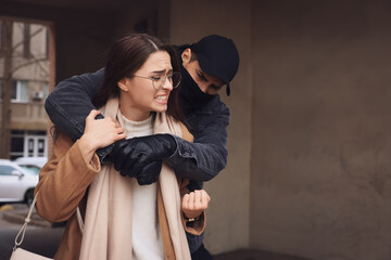 Woman defending herself from attacker in alley, space for text