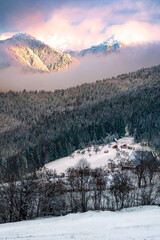 winter landscape with mountains, village and snow at sunset