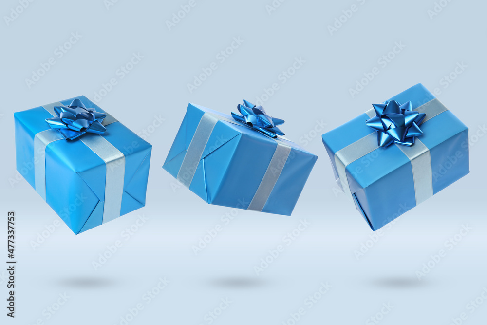 Poster Beautifully wrapped gift boxes flying on light background