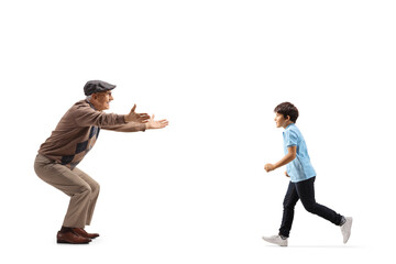 Full length profile shot of a boy running to hug his grandfather