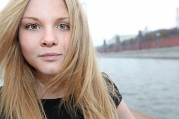 Girl - blonde looks attentively into the camera. She floats down the river on a ship