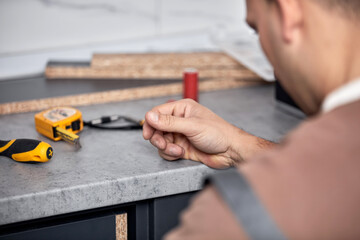 Handyman making kitchen wall cabinets in the apartment.