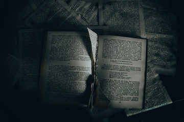 An old book with a torn page lies in an abandoned building. Gloomy atmosphere. An old book....