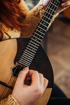Domra Folk Musical Instrument. Female hands with 4 strings Natural Wood Handmade Musical Instrument Domra Close up