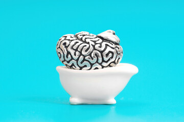 Human brain in a miniature bathtub on blue