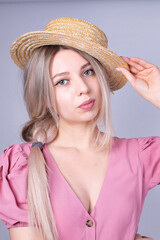 Portrait of woman with blonde hair and white skin isolated on grey in pink