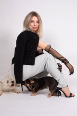 Young european woman with white skin isolated on grey with a small dog