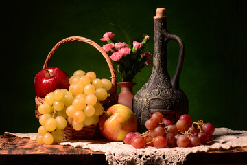 Obraz z winem w tle. Martwa natura a w niej świeże owoce takie jak winogron czerwona, biała, jabłka, mandarynki klementynki oraz limonka z bukietem goździków. kompozycja na pulpit czy obraz na ścianę - obrazy, fototapety, plakaty
