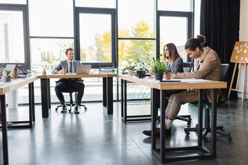 young and smiling multicultural business people working in modern office.
