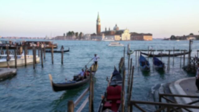 Blurred defocused view of gondole ride a couple in romance boat on travel vacation holidays with historic church of San Giorgio Maggiore in background of Venice Italy. Romantic travel 