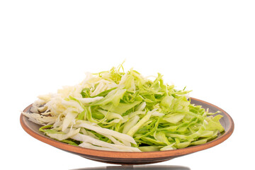 Fresh shredded white cabbage on a clay dish, close-up, isolated on white.