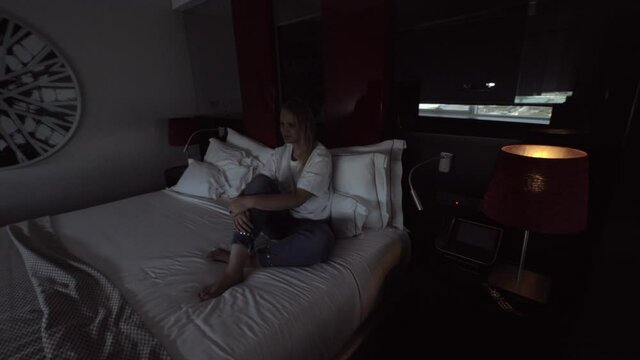 Woman sitting in a hotel room and turning on the automatic window opening system