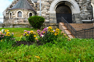 Fototapeta na wymiar Blooming flowers in front of the Church of Alesund, Norway.