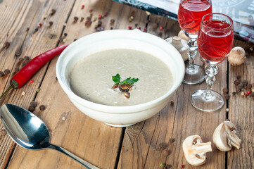 mushroom cream soup on a wooden background with mushrooms and spices
