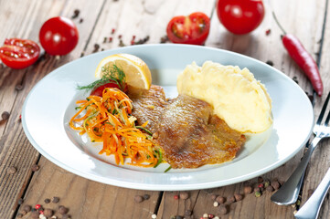 fried fish with mashed potatoes and salad on a white plate
