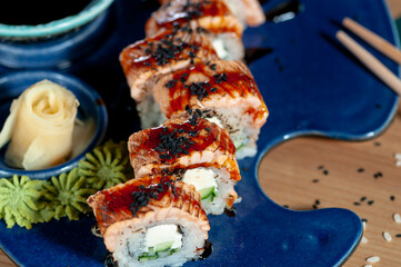 sushi roll with eel and sire philadelphia on a blue plate close-up
