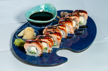 sushi roll with eel and philadelphia sire on a blue plate on a white plate
