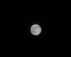 Bright white moon on a black dark night background
