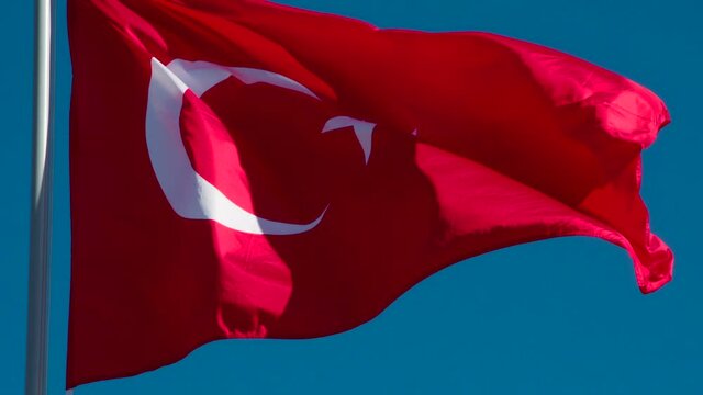 State Flag of Turkey. The Big State Flag is illuminated by the sun and flutters epically in the wind against the blue sky. Slow Motion 120 fps