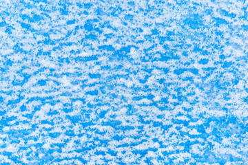 White snow abstract pattern on blue surface wall texture, winter, cold background