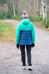 Fototapeta premium Single elderly woman walking alone in forest for good mental and physical health