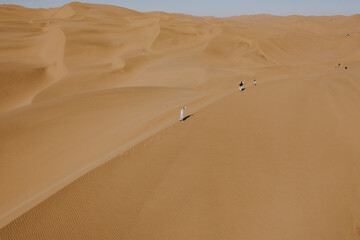Aerial view of people doing a photo shooting on the sand dunes near Walvis Bay, Namibia.