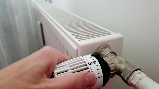 Hand moves temperature level. Battery temperature controller.  Thermostat closeup. Middle position. Normal temperature