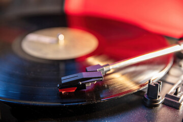 Turntable vinyl record player, disco neon light background. Needle on the disc, close up view.