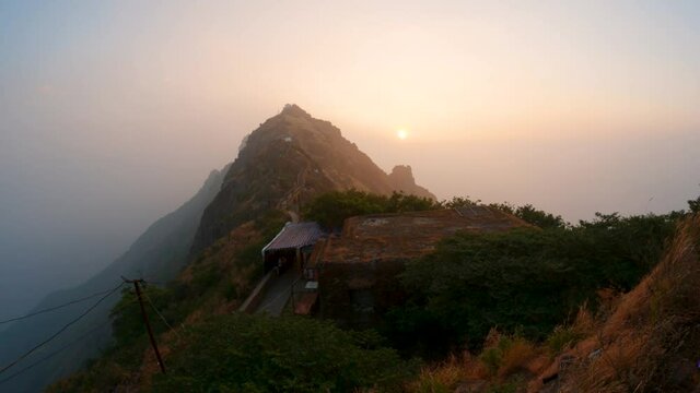 4K time lapse of a sunrise over Girnar mountain. Beautiful winter morning landscape background, with mountains range, orange and yellow sky