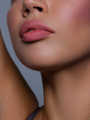 Obraz premium Cosmetics, makeup and trends. Bright lip gloss and lipstick on lips. Closeup of beautiful female mouth with natural lip makeup. Beautiful part of female face. Perfect clean skin in natural light