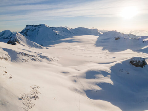 Aerial view of Plain Morte Glacier on an early sunny winter day with ski tracks in Switzerland.