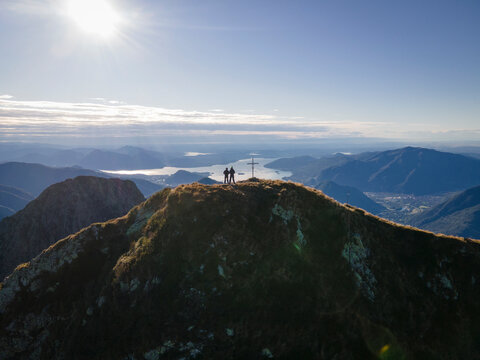 Aerial view of two friends standing on peak Proman in Val Grande National park in Premosello-Chiovenda, Italy.