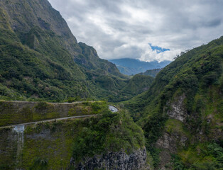 Aerial view of a vehicle driving a twisty road along the mountain near Saint Louis, Reunion.