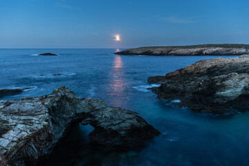 Full moon on the coast of Galicia, with lighthouse, natural rock arches, etc!