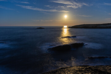 Full moon on the coast of Galicia, with lighthouse, natural rock arches, etc!