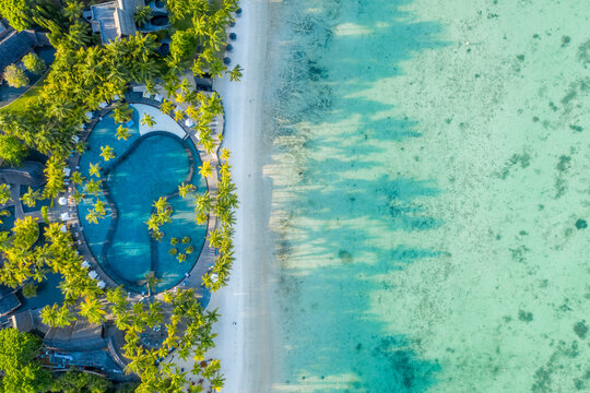 Aerial view of a beautiful swimming pool with palm trees in a luxury resort, Trou aux Biches, Mauritius.