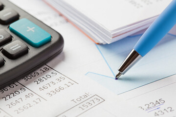 Accounting document with pen,color diagram and checking financial chart. Concept of banking, financial report and financial audit. In blue color.