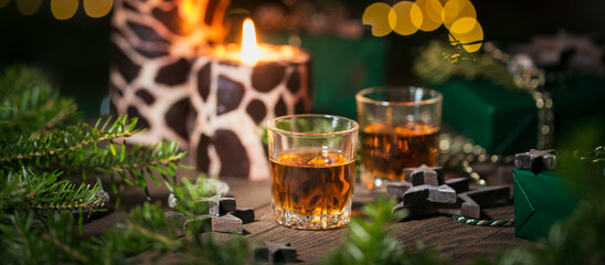 Two shot glasses of whiskey or bourbon with Holiday decoration