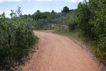Fototapeta na wymiar Dry hiking path with wooden fence ahead