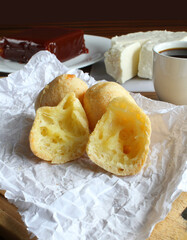 Traditional brazilian snack called 'pão de queijo' with guava paste, white cheese and cup of coffee on the background. Seletive focus.