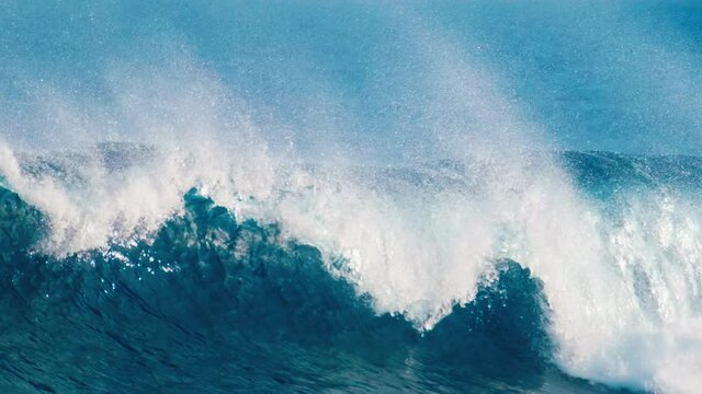 Powerful blue ocean wave breaks