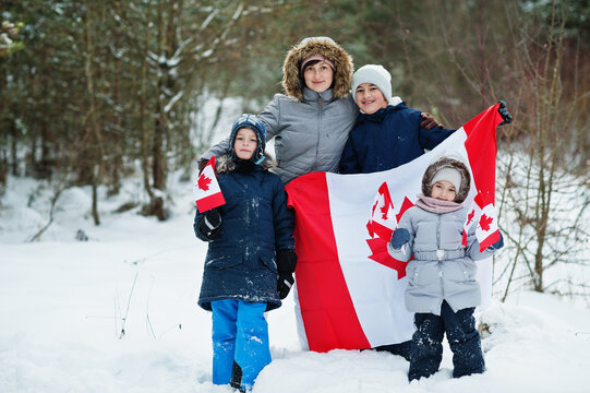 Mother With Kids Holding Flag Of Canada On Winter Landscape.