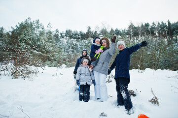 Fototapeta na wymiar Mother with four children in winter nature. Outdoors in snow.