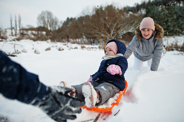 Fototapeta na wymiar Mother playing with children in winter nature. Outdoors in snow.