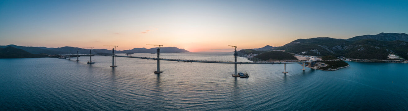 Aerial view of Peljesac bridge, a suspended railroad and highway under construction crossing the Bay of Mali Ston in Croatia.