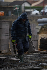 Man working on a construction site under the rain