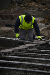 Fototapeta na wymiar Man working on a construction site under the rain