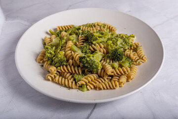 Fusilli pasta with broccoli on a white background. Typical vegetarian food.