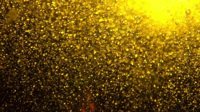 Goldener facettenreicher dynamischer Hintergrund mit jeder Menge kleiner Partikel und Blubberblasen. Golden multi-faceted dynamic background with lots of small particles and bubbles.